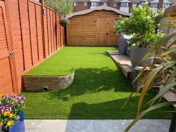artificial grass installation with patio in garden